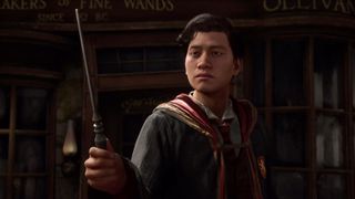 Hogwarts Legacy - A Gryffindor student holds his wand up while standing in Hogsmeade.