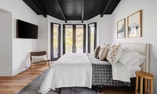 A bedroom with a vaulted ceiling painted black