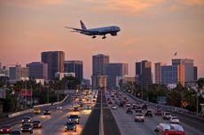 Airplane flying over city.