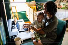 mum with kid sat on lap at computer