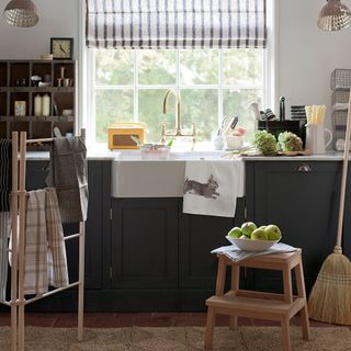 utility room with storage units and classic stripe blinds