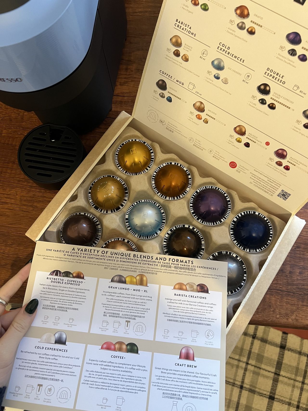 Image of a box of Vertuo coffee pods in different colors and sizes and a flavor guide sheet beside it.