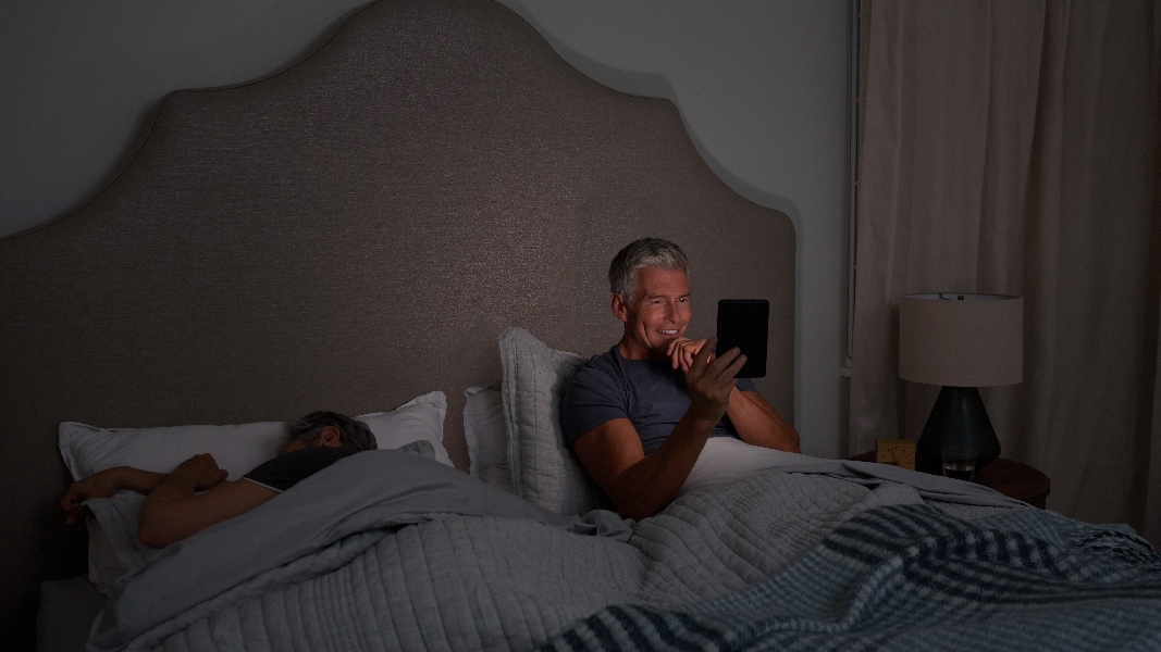 A man using the Amazon Kindle (2022) in bed