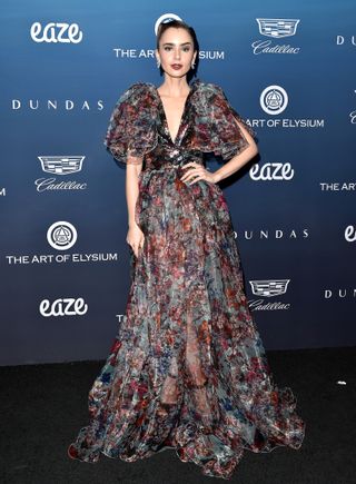 Lily Collins attends The Art of Elysium's 12th Annual Celebration - Heaven, on January 5, 2019 in Los Angeles, California wearing an Elie Saab puff-sleeve gown, Yeprem diamond earrings, and Christian Louboutin platform sandals.