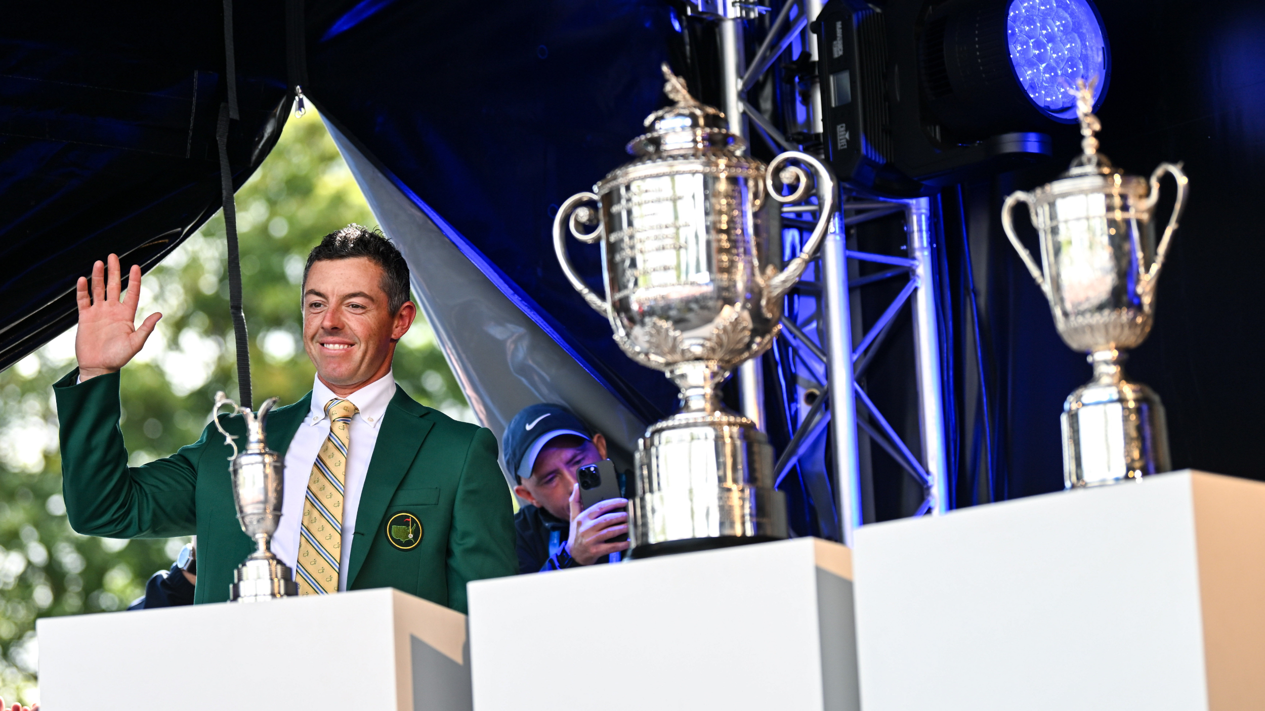 Rory McIlroy wearing his Green Jacket with the Major trophies