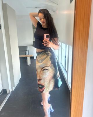 @rosalia.vt wears a printed skirt and a black t-shirt.