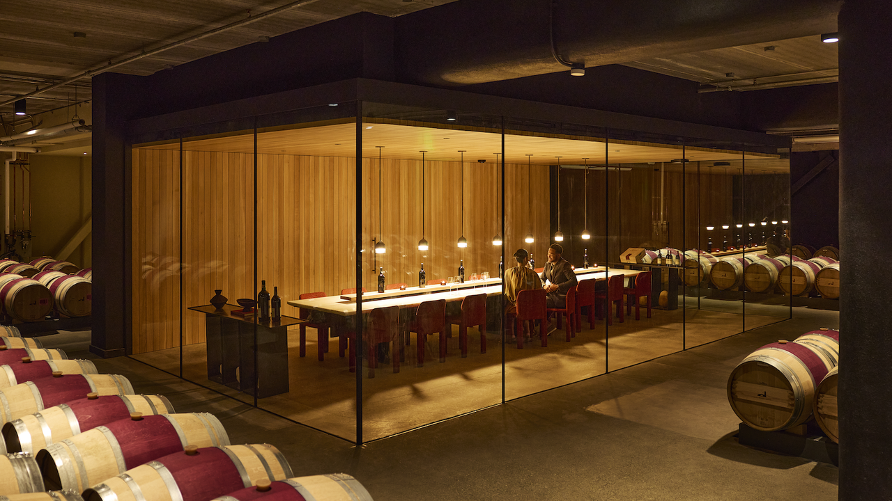 Two guests in an intimate, glass-enclosed tasting room within Robert Mondavi Winery's barrel cellar.