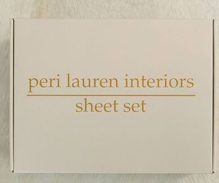 A box of Peri Lauren Interiors bedding against a white background.