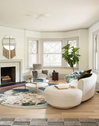 White living room with curved sofas and fiddle leaf tree