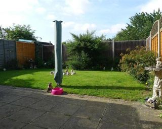 The before shot of a 20 x 15ft garden with lawn and paved patio area near the house