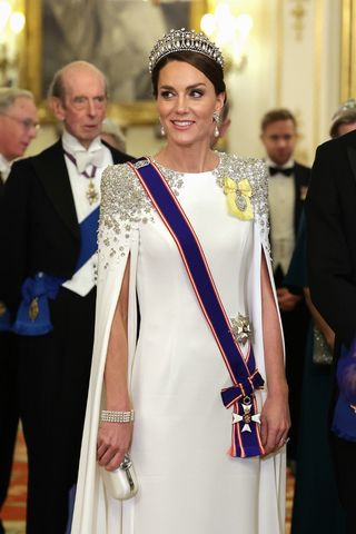 Catherine, Princess of Wales carries a metallic clutch bag during the State Banquet at Buckingham Palace on November 22, 2022 in London, England.