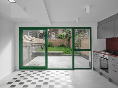inside terrace house extension looking out through green window frames