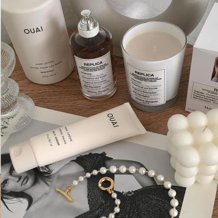 A coffee table with a stylish book and a luxury candle