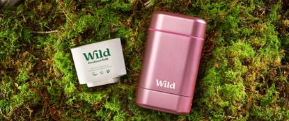 Pink roll on deodorant with refill next to in on the ground