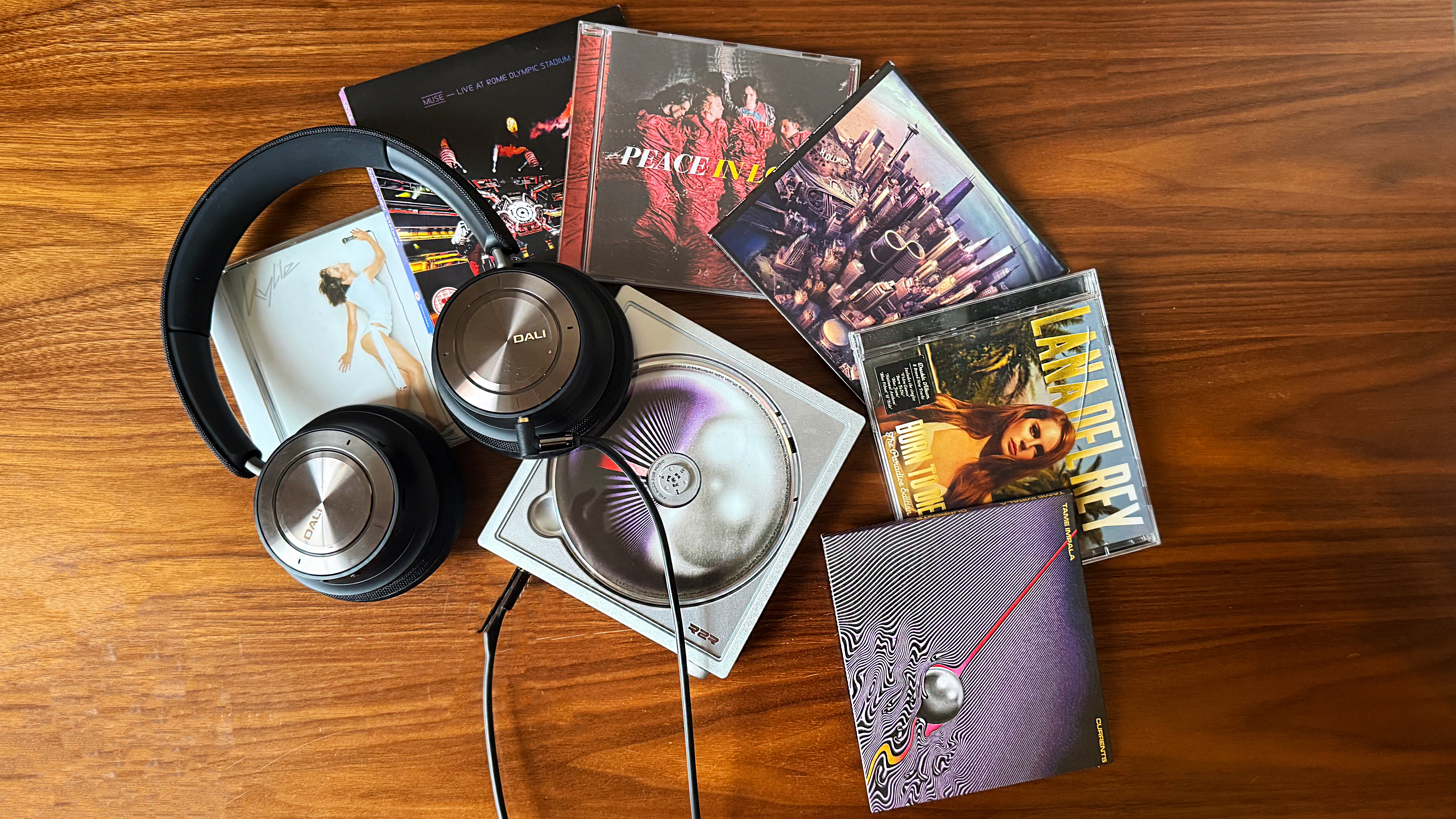 a photo of the fiio dm15 cd player surrounded by cds and dali headphones