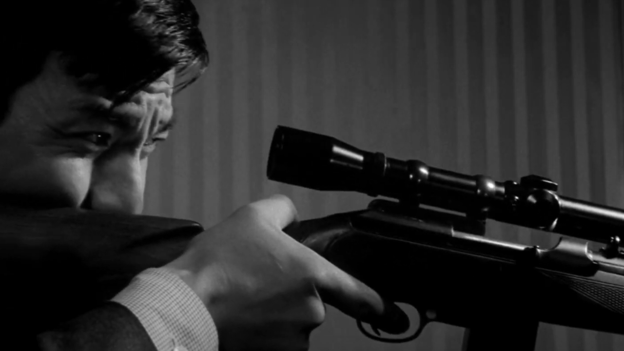 A man holding a rifle in A Colt Is My Passport