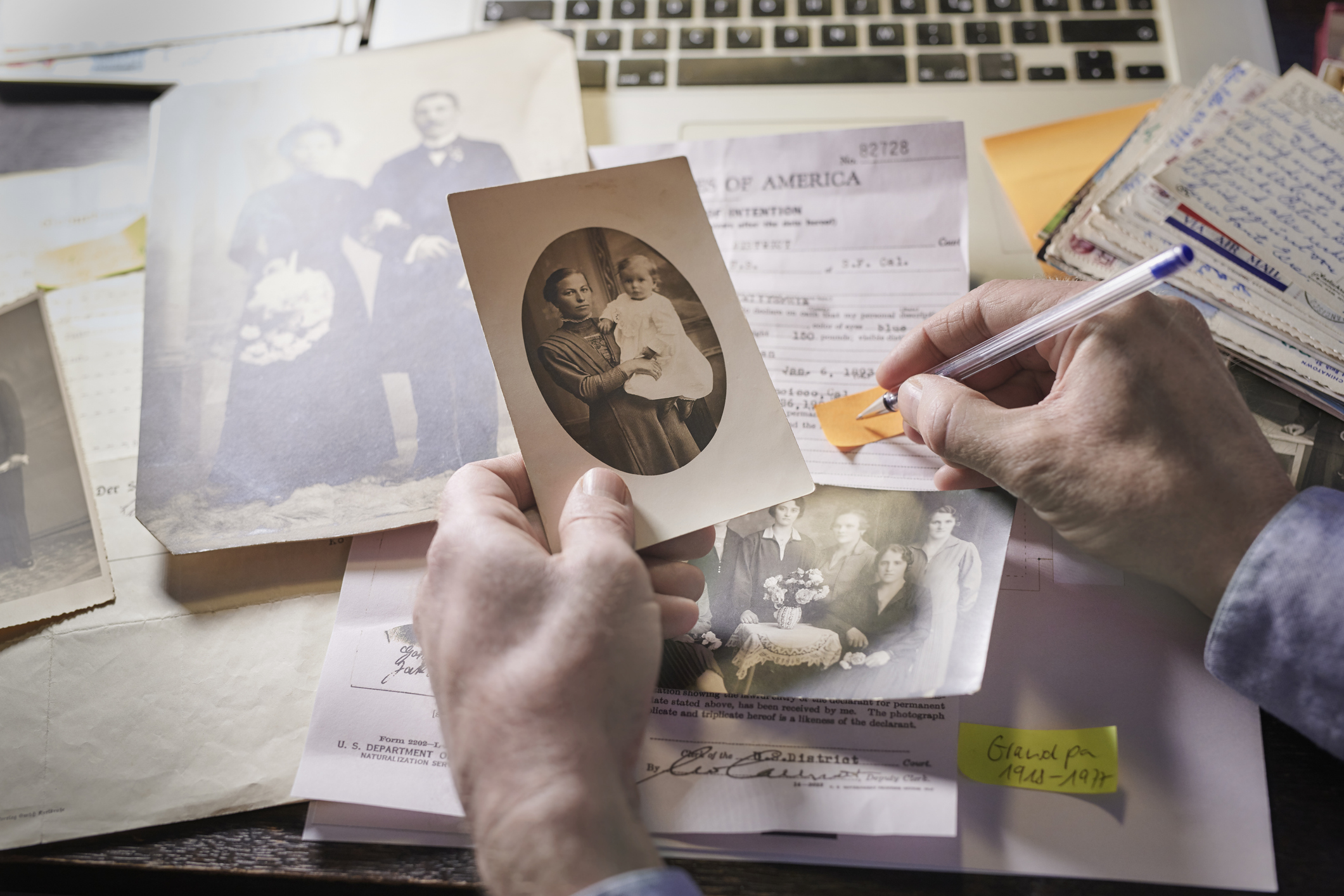 Man doing research on family members looking at old photographs