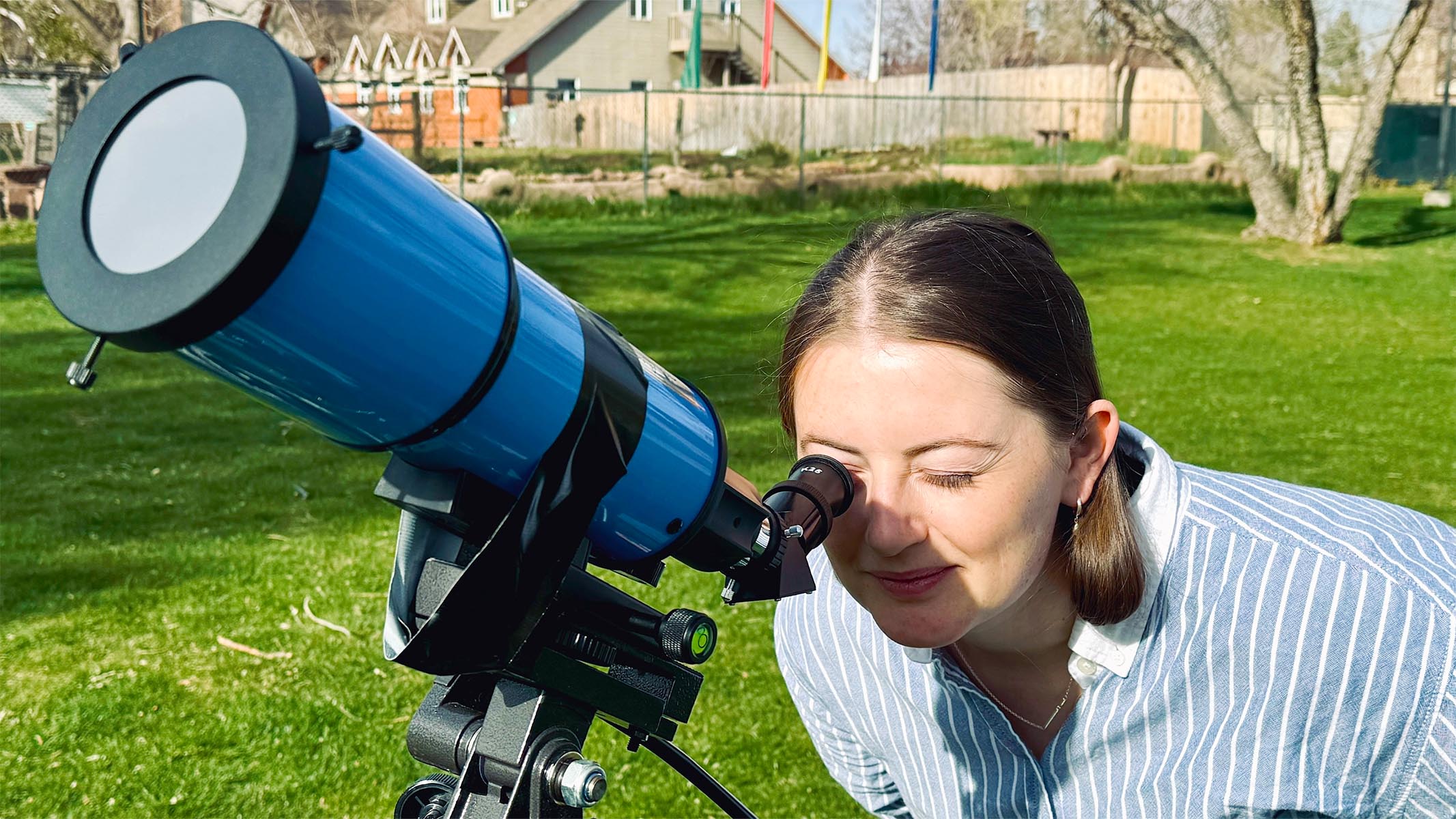 iOptron 80mm white light solar telescope being used by a female observer