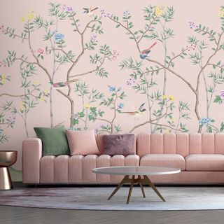 living room with a pink sofa and pink wall mural with pretty trees and birds