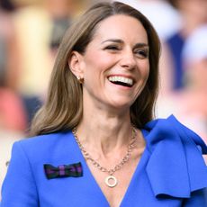 Kate Middleton wearing a blue dress and laughing