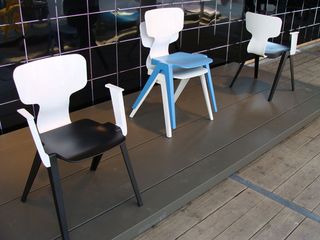 Four plastic chairs in black and white, plain white, and white and blue