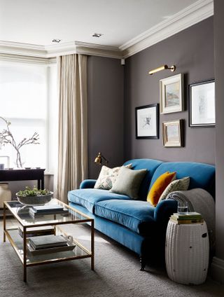Pillows on a sofa in a purple-hued living room