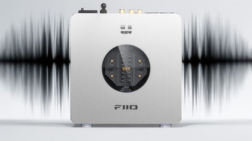 Product shot of the FiiO K13 R2R DAC on a light grey background with a black sound wave image behind it