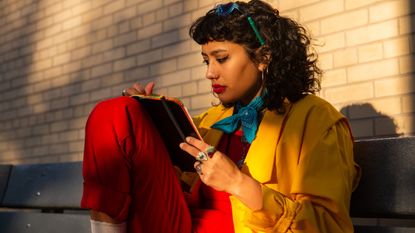 woman writing on notebook at sunset in park - stock photo