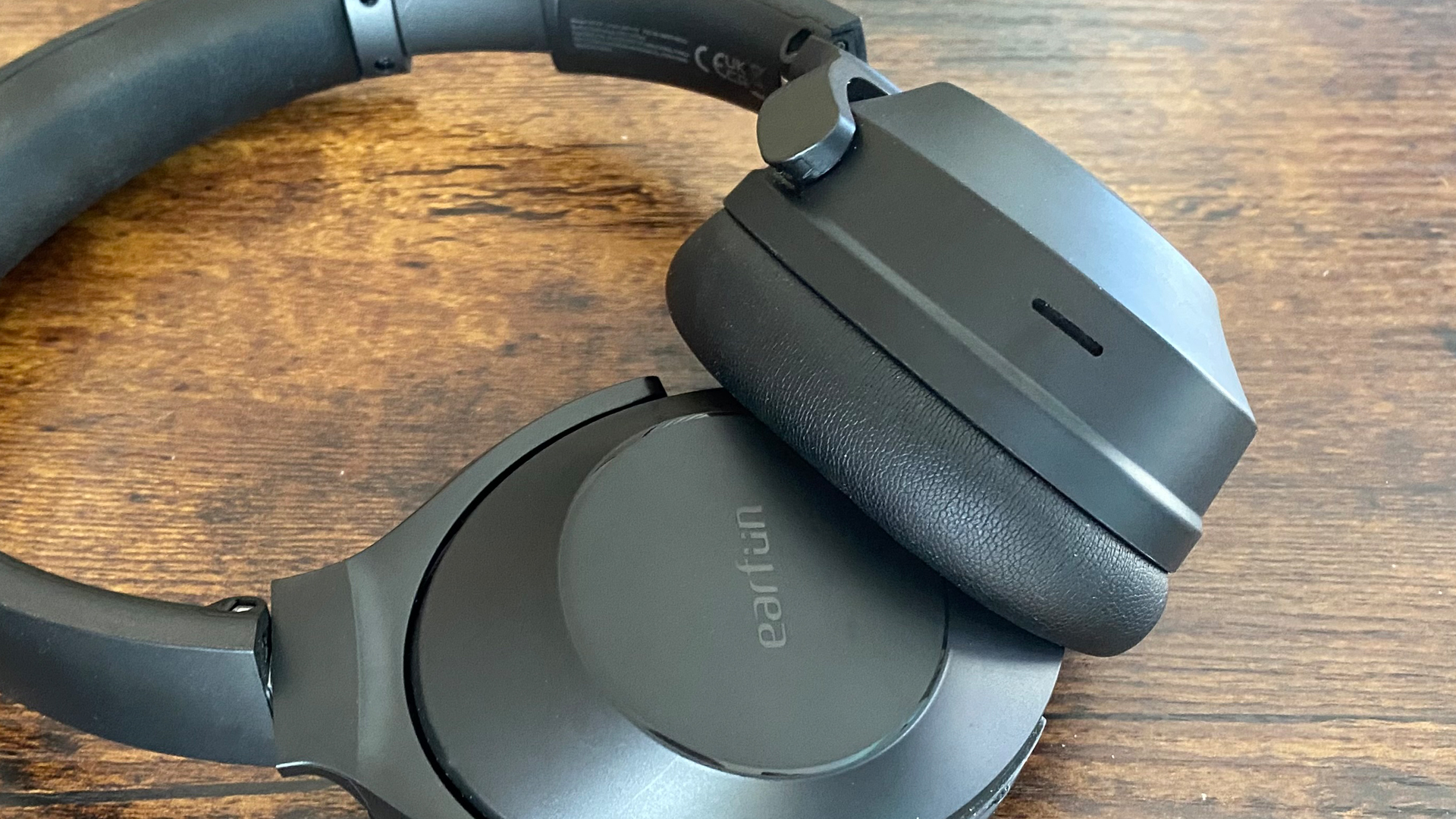 Earfun Wave Life over-ear headphones on a wooden surface