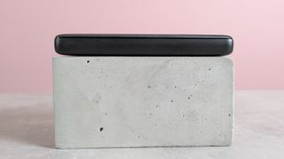 Side view of Anker PowerCore Essential 20000 on plinth on desk with pink background