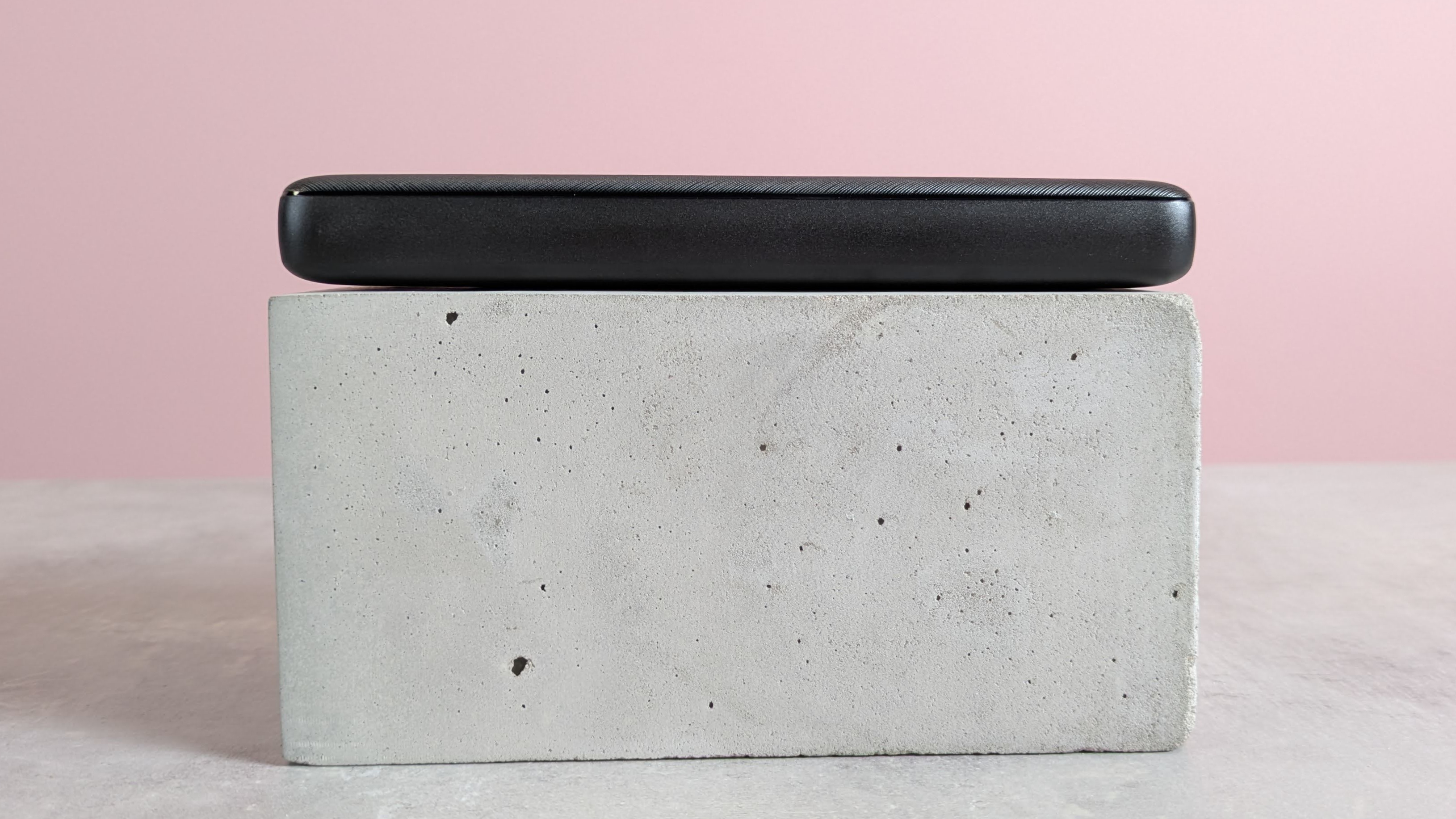 Side view of Anker PowerCore Essential 20000 on a pink background on a table