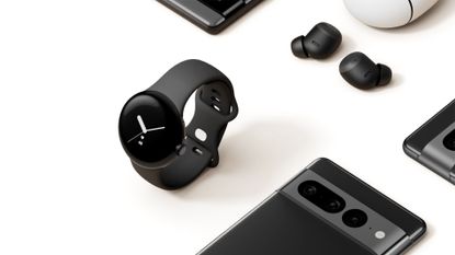 Google Pixel Watch positioned next to Pixel Buds and Pixel 7 phone, all in black colourway
