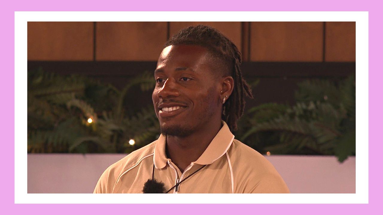 Love Island&#039;s Shaq Muhammad pictured smiling, wearing a cream top while standing around the fire pit in episode 17 of Love Island 2023/ in a purple template