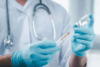 A doctor holding a vaccine vial and syringe.