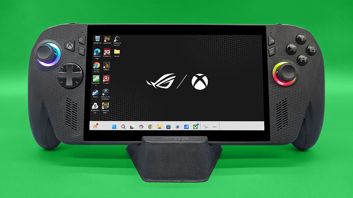 ROG Xbox Ally X held upright in its stand and showing the main background that features the ASUS ROG logo and the Xbox logo.