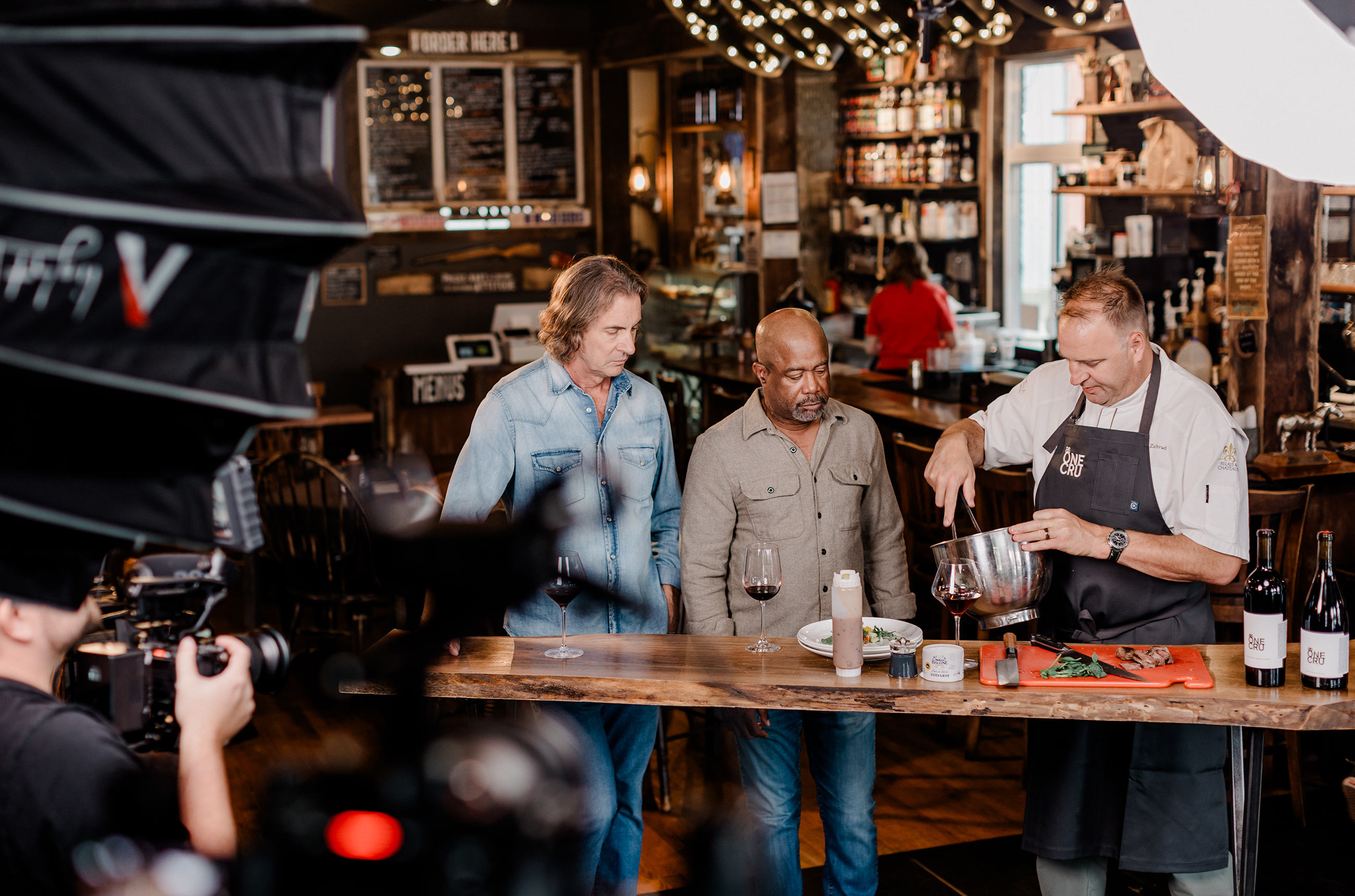 Darius Rucker and Chris Radomski with a chef, in front of a camera
