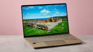 Three-quarter view of Asus Zenbook 14 2026 on a desk with pink wall in background