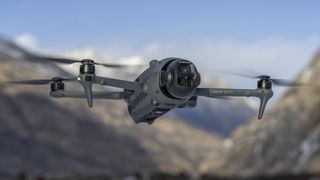 DJI Mavic 4 Pro drone in flight with snowcapped mountain backdrop