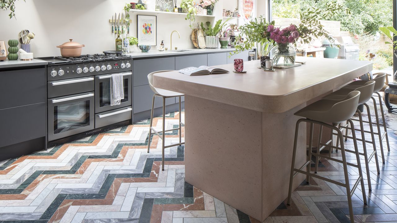 Kitchen with pink island and colourful chevron flooring