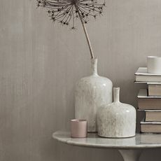 books and ceramic flower vase on round table