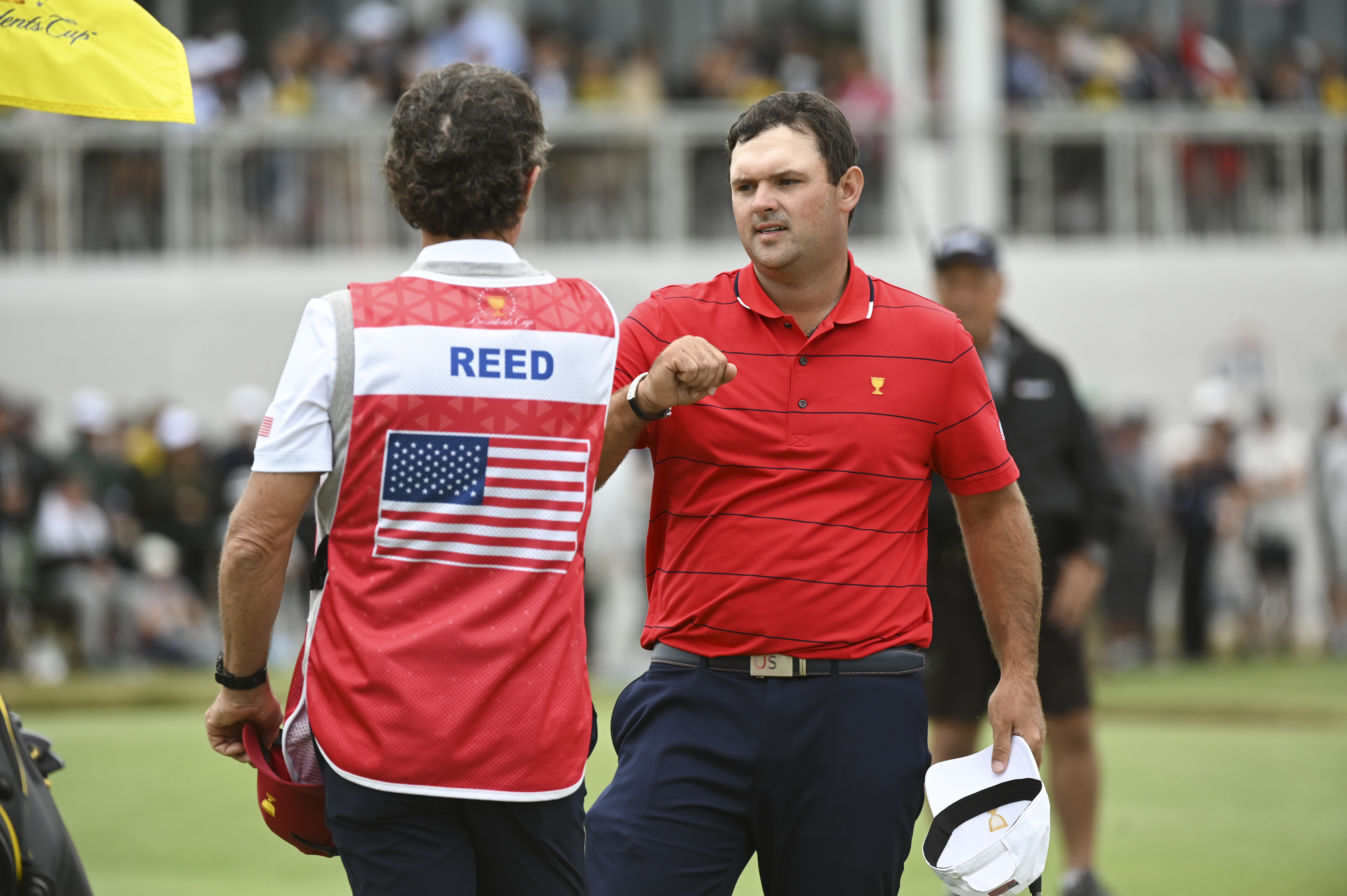 Patrick Reed shakes hands with his caddie at the Presidents Cup