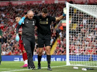 Liverpool goalkeeper Alisson leaves the pitch after picking up an injury