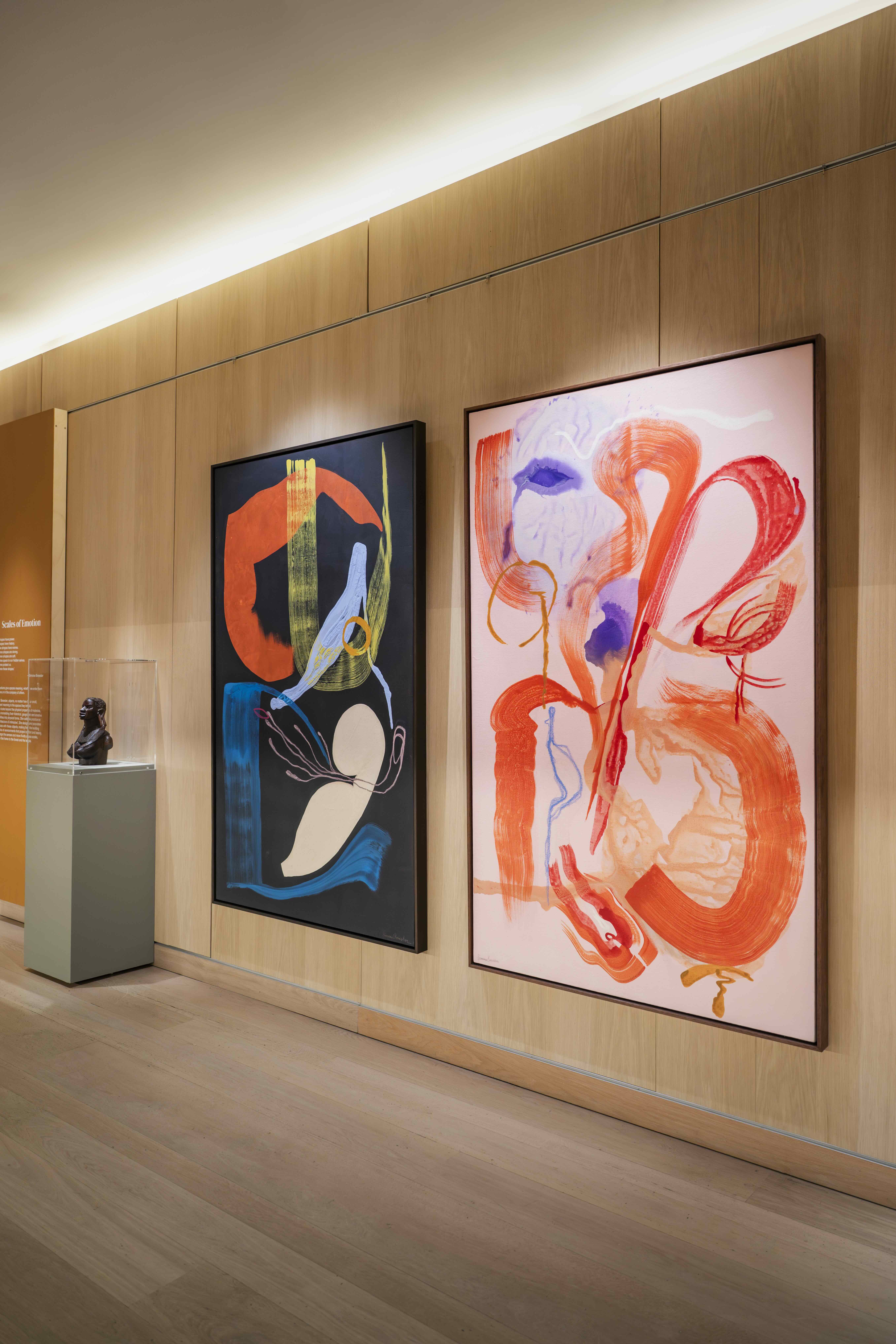 Paintings by Simone Brewster hanging on the wall of the Design Museum in London