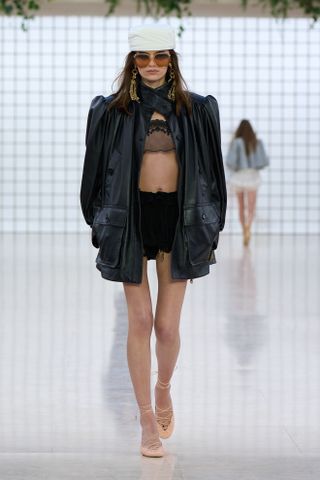 A Chloé runway model wearing an all-black outfit in the spring/summer 2025 collection.