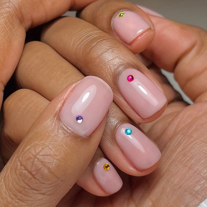 Pale pink nails with small gems.