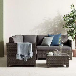 A dark brown rattan outdoor corner sofa