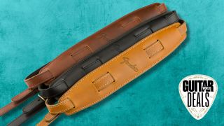 Three leather Fender guitar straps on a teal background