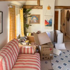 Playroom with pile of cardboard boxes beside striped sofa