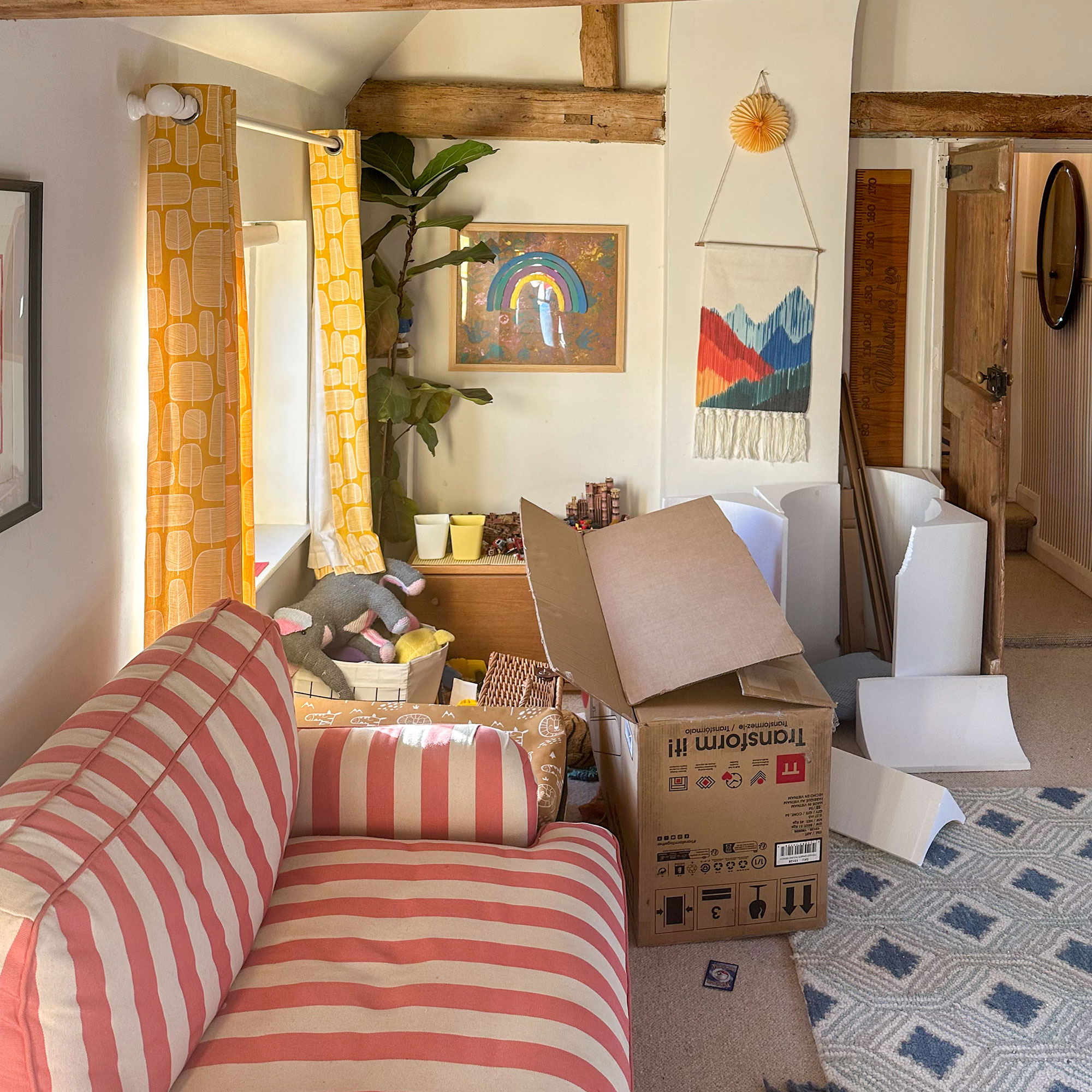 Playroom with pile of cardboard boxes beside striped sofa