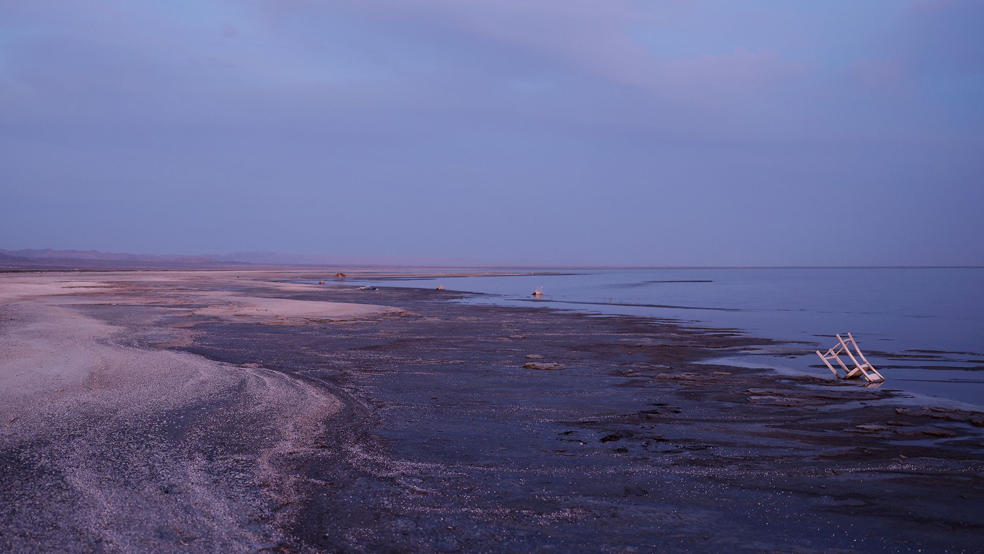 A view of a beach with various pieces of trash on it.
